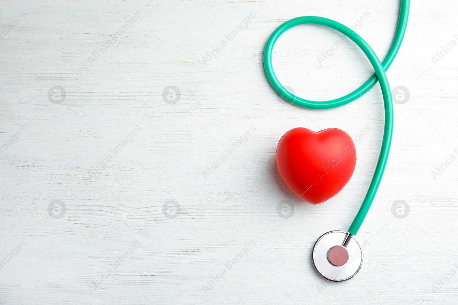 Photo of Stethoscope and red heart on wooden background, top view with space for text. Cardiology concept