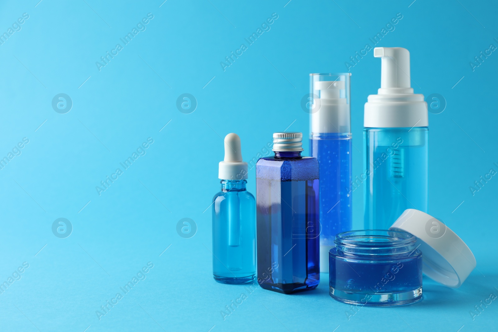 Photo of Set of luxury cosmetic products on light blue background. Space for text