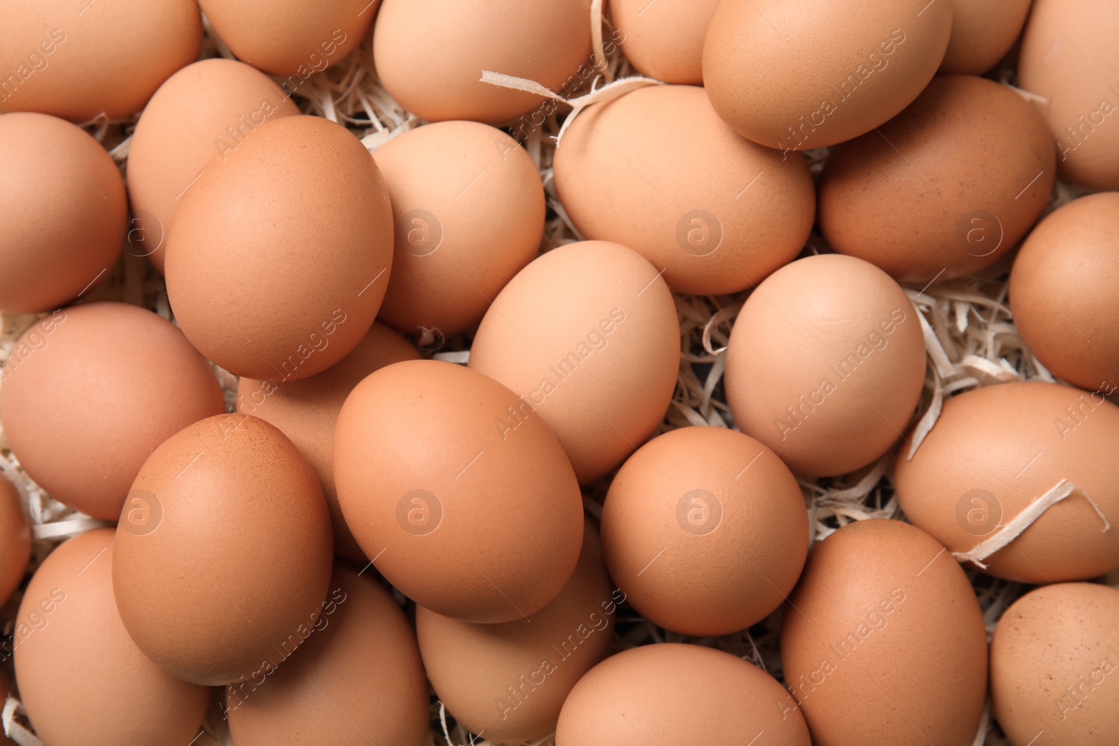 Photo of Pile of raw brown chicken eggs, top view