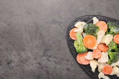 Photo of Mix of different frozen vegetables on grey table, top view. Space for text