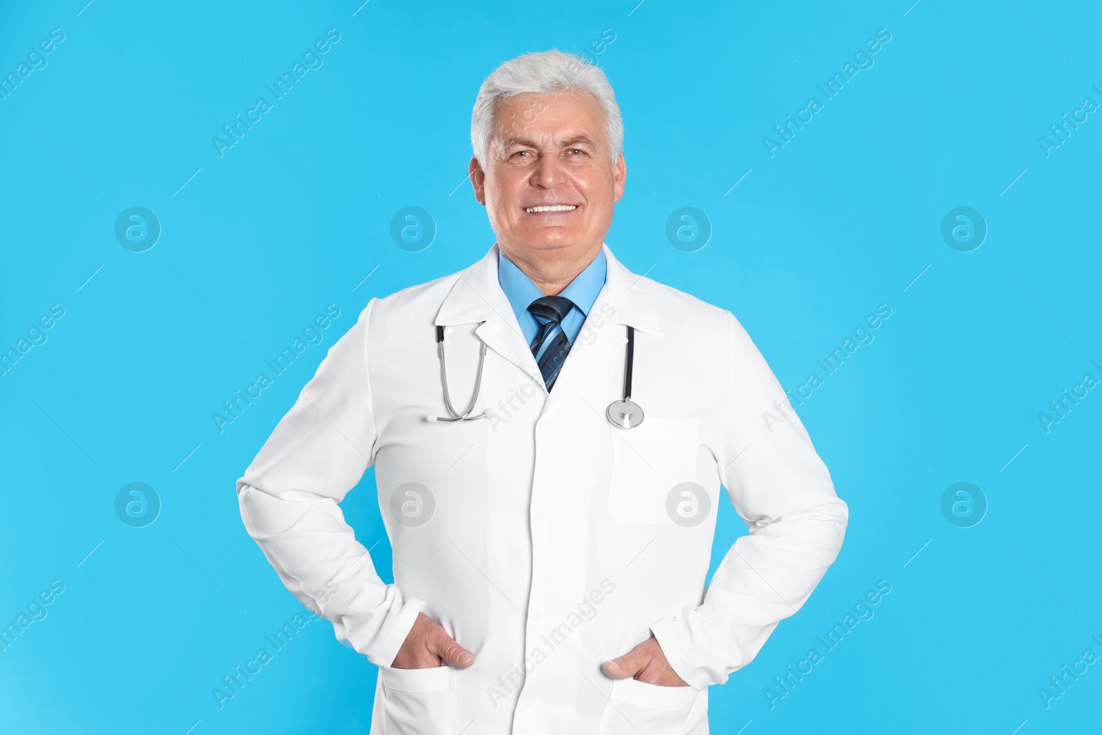 Photo of Senior doctor with stethoscope on light blue background