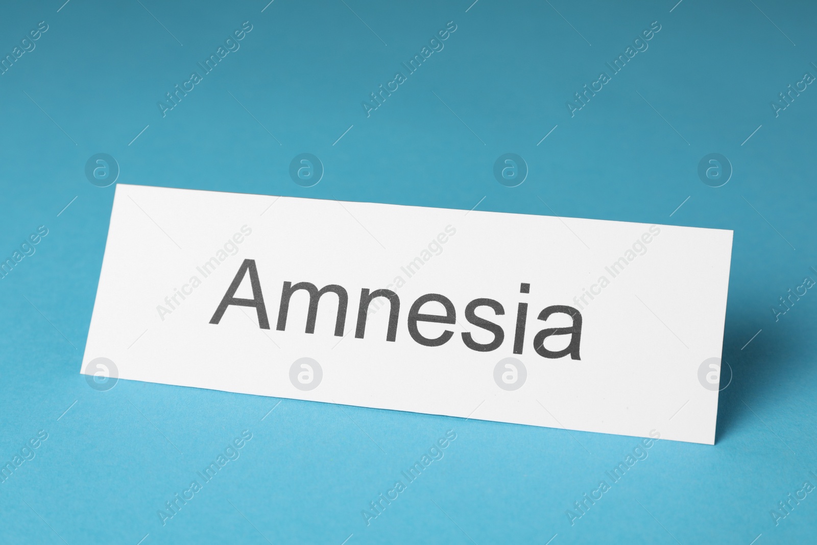 Photo of Card with word Amnesia on light blue background