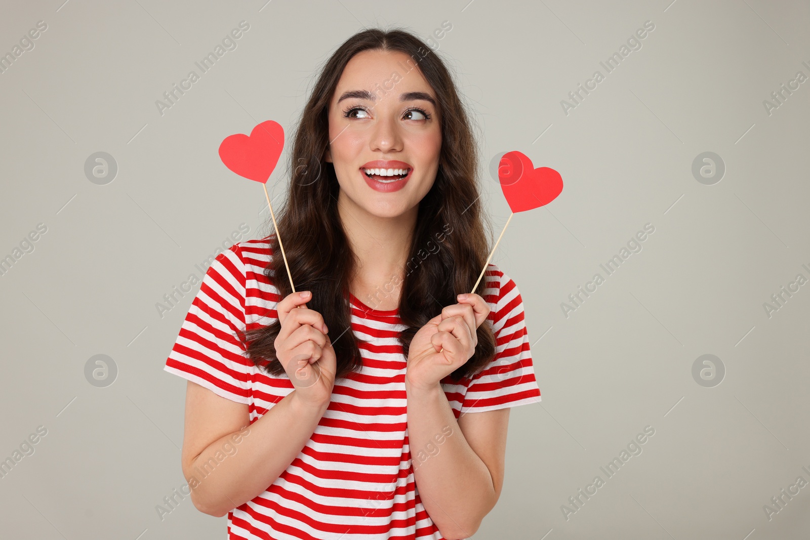 Photo of Beautiful young woman with paper hearts on grey background