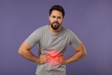 Image of Man suffering from stomach pain on purple background