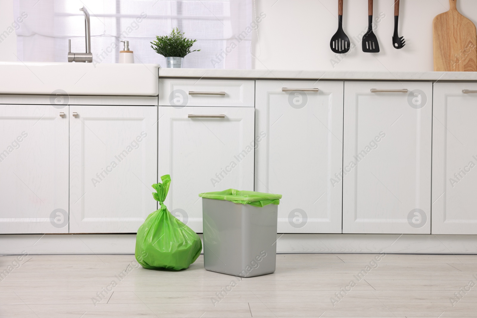 Photo of Plastic garbage bag and trash can in kitchen