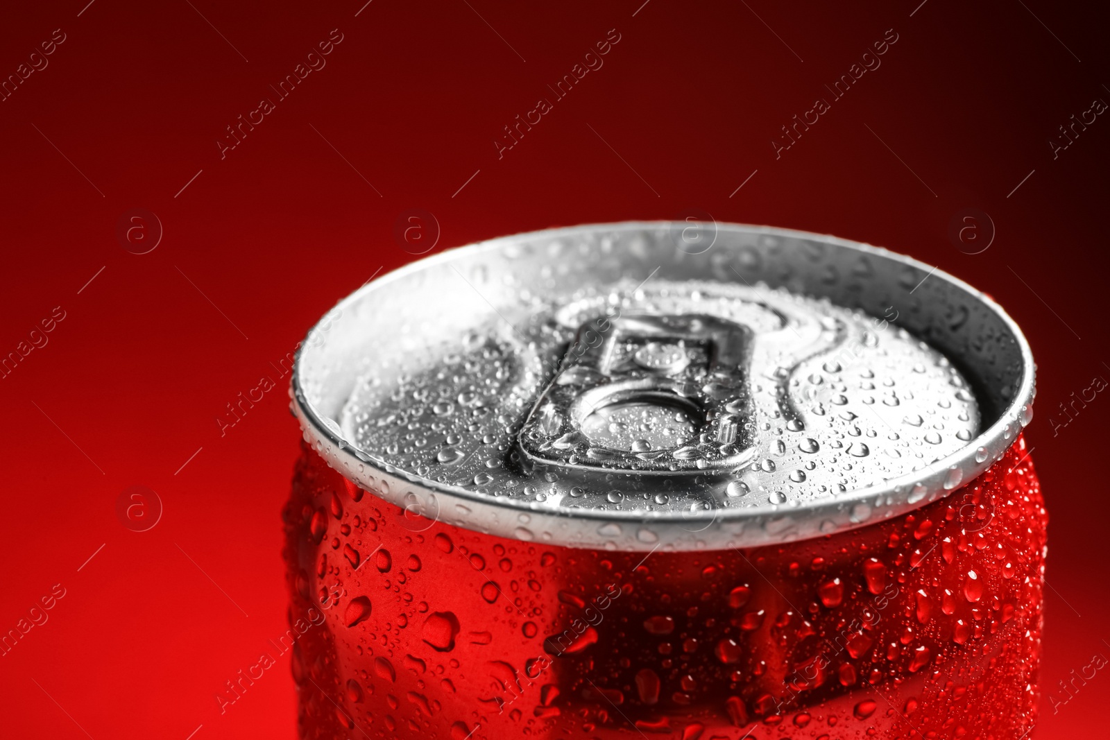 Photo of Wet closed can on red background, closeup