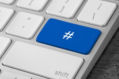 Blue button with hashtag sign on computer keyboard, closeup