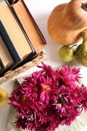 Autumn flat lay composition with beautiful chrysanthemum flowers and books on white wooden table