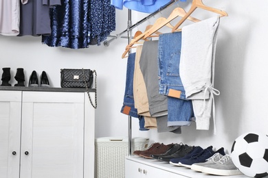 Modern dressing room with different stylish clothes and shoes