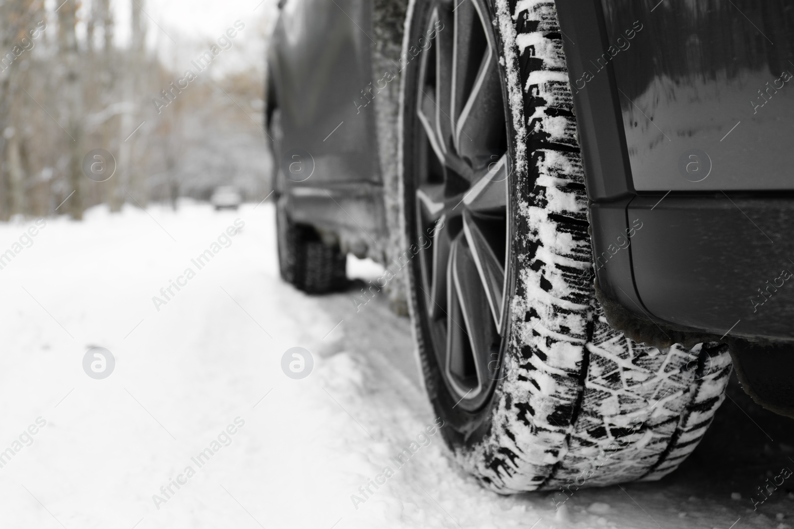 Photo of Snowy country road with car on winter day, closeup