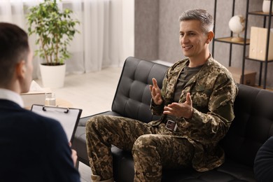 Photo of Professional psychotherapist working with military man in office