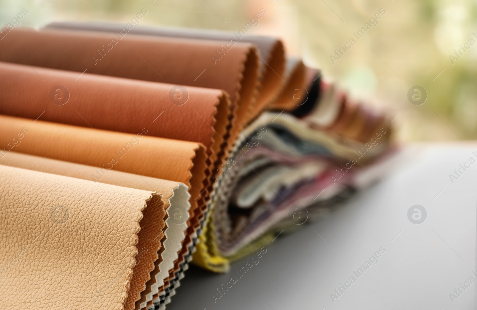 Photo of Leather samples of different colors for interior design on table