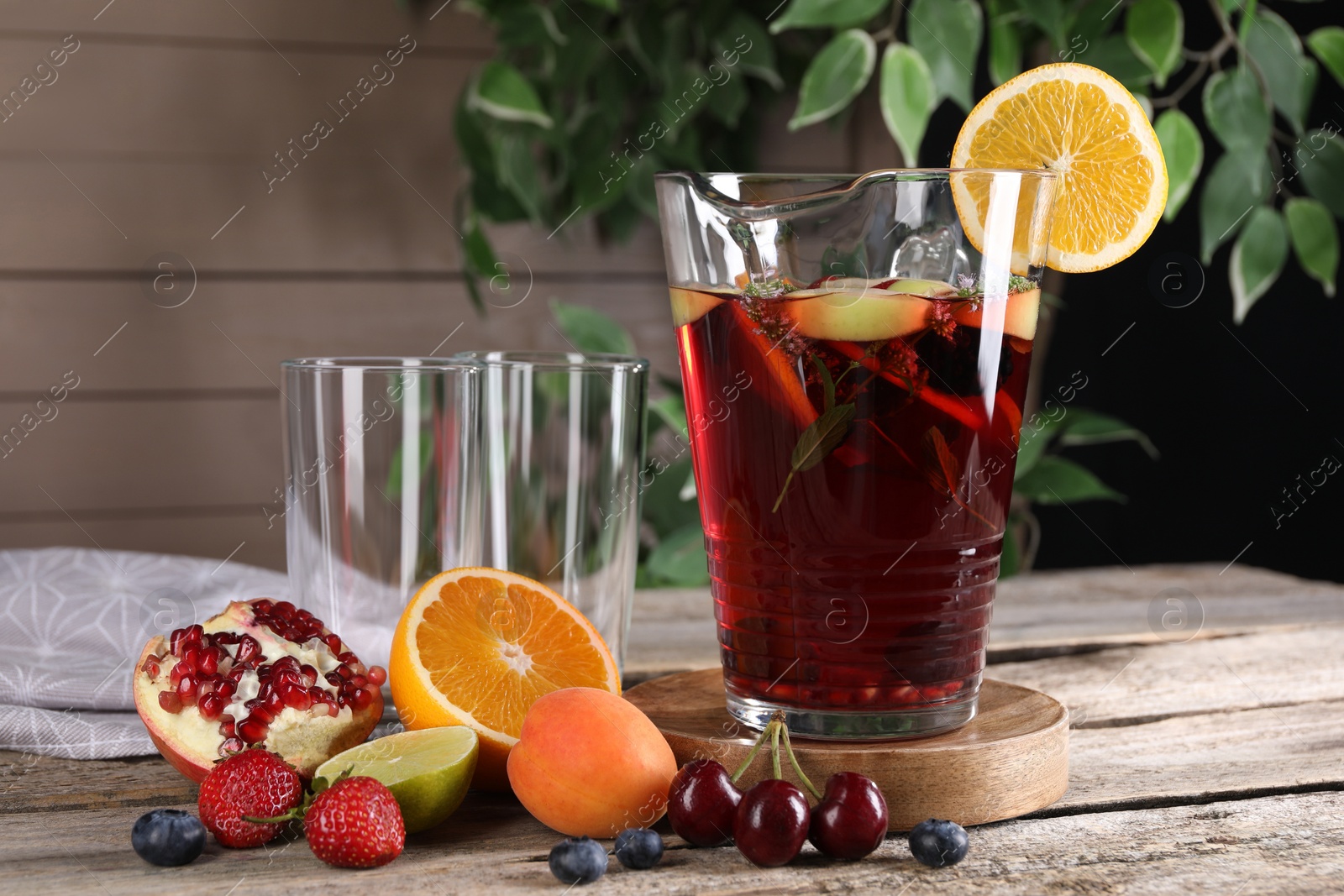 Photo of Delicious refreshing sangria with fruits and berries on old wooden table