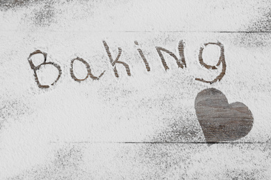 Photo of Composition with word BAKING and heart made with flour on wooden table, top view