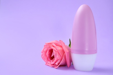 Photo of Composition with natural female roll-on deodorant on purple background, space for text