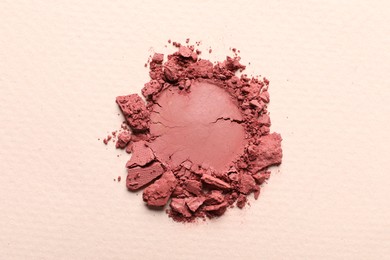 Photo of Crushed eye shadow on beige background, top view