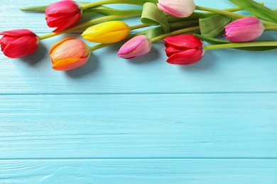 Photo of Beautiful tulips and space for text on wooden background, top view. Spring flowers