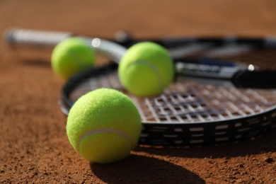 Tennis balls and rackets on clay court, closeup