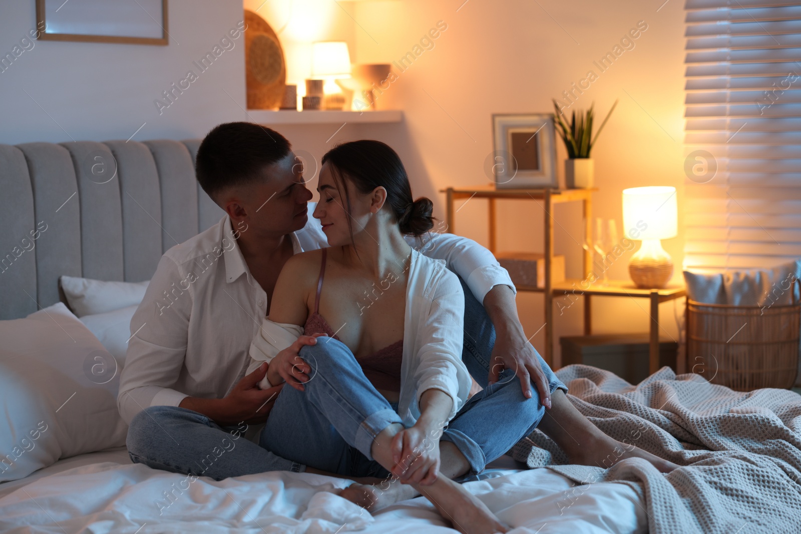 Photo of Affectionate couple enjoying each other on bed at night