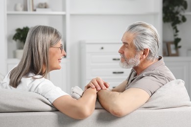 Affectionate senior couple relaxing on sofa at home