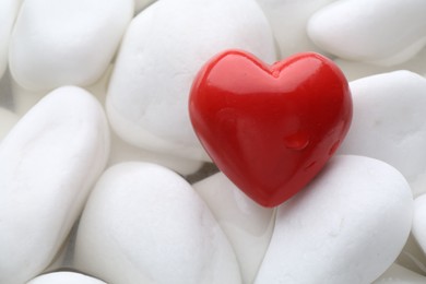 Photo of Red decorative heart on stones and water, top view. Space for text