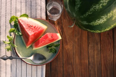 Flat lay composition with tasty ripe watermelons on wooden table. Space for text