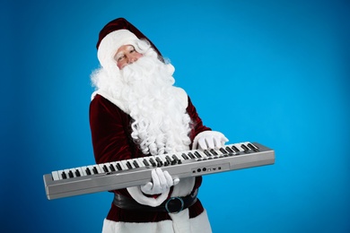 Santa Claus with synthesizer on blue background. Christmas music
