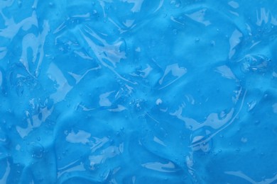Photo of Pure transparent cosmetic gel on blue background, closeup