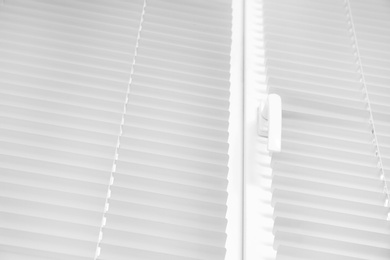 Photo of Window with modern horizontal blinds indoors, closeup