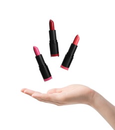 Image of Woman making lipsticks levitate on white background, closeup. Decorative cosmetics