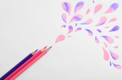 Photo of Abstract drawing and colorful pencils on white background, top view