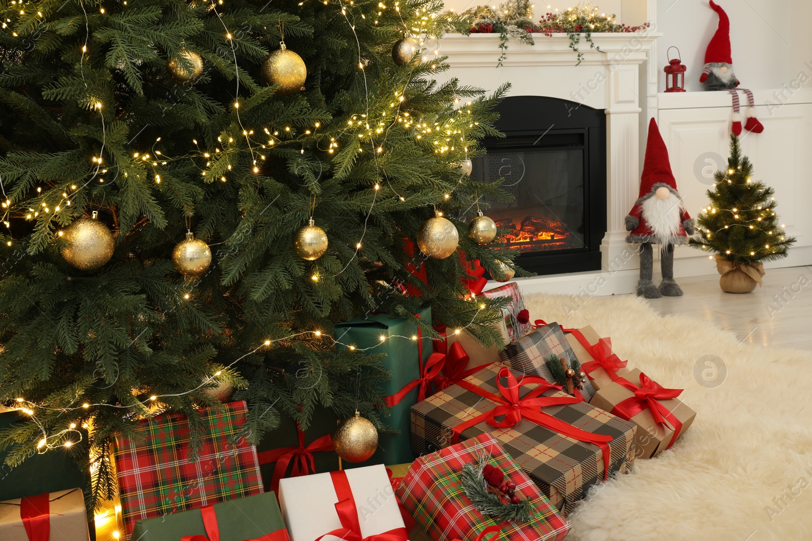 Photo of Many gift boxes under beautiful Christmas tree in room