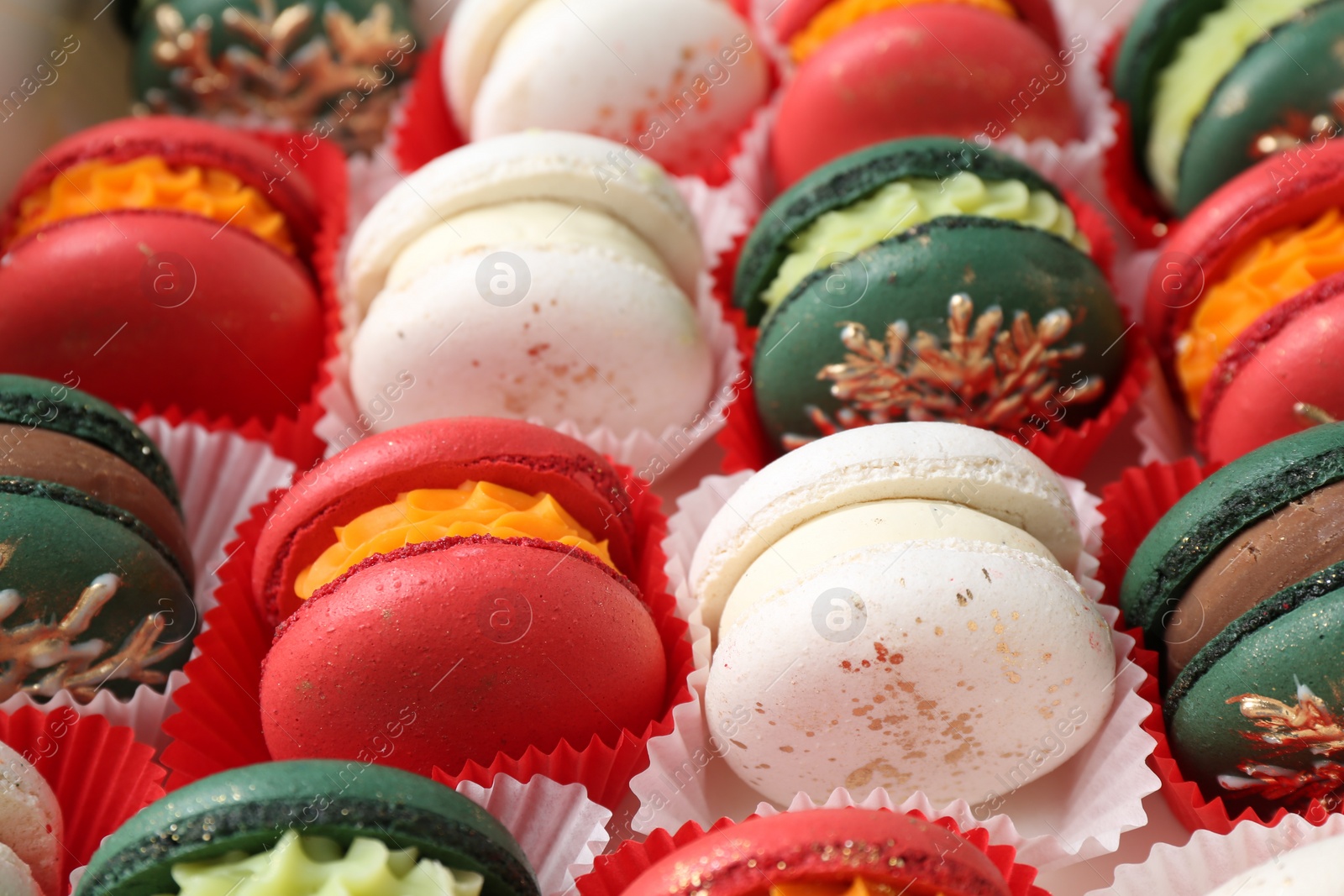 Photo of Different beautifully decorated Christmas macarons on table, closeup