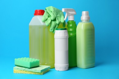 Photo of Cleaning supplies and tools on light blue background