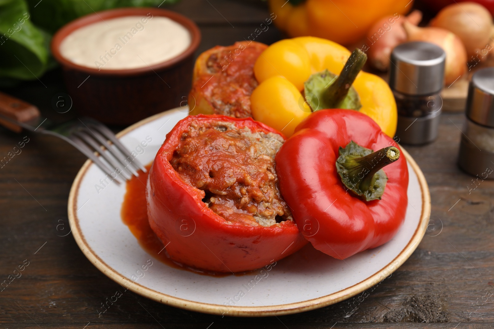 Photo of Delicious stuffed bell peppers served on wooden table