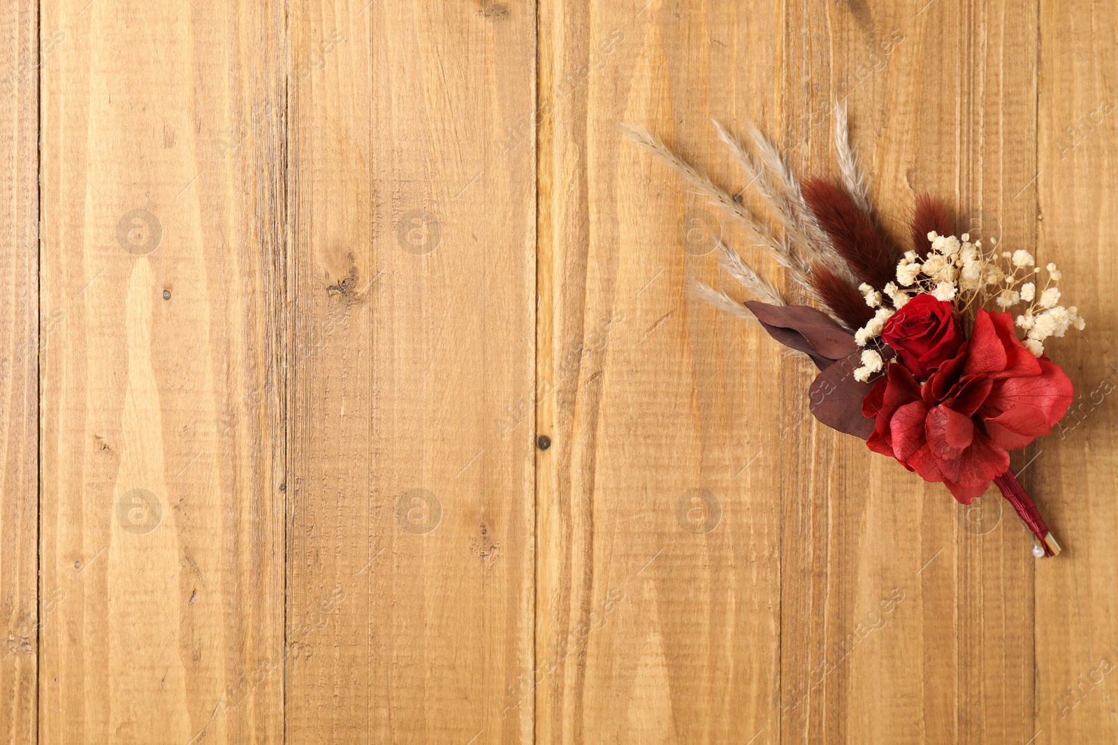 Photo of Beautiful boutonniere on wooden background, top view. Space for text