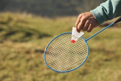 Photo of Man playing badminton outdoors on sunny day, closeup. Space for text