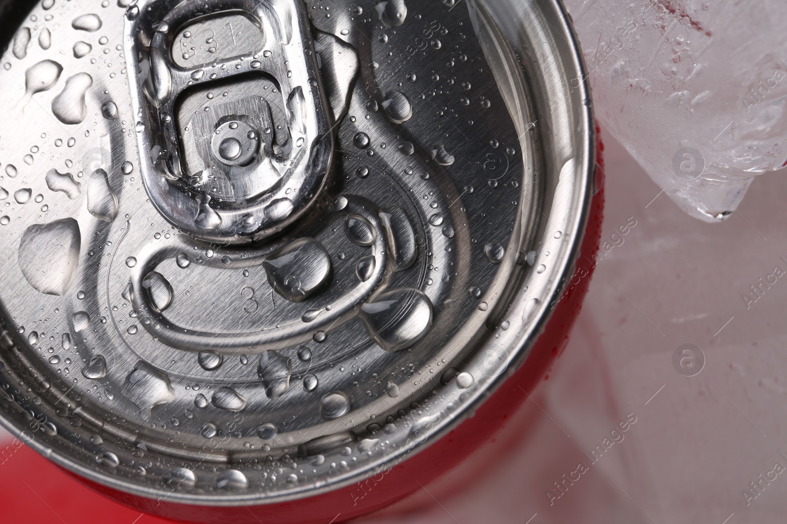 Photo of Energy drink in wet can and ice cubes, closeup