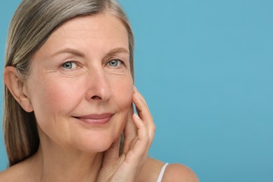 Portrait of senior woman with aging skin on light blue background, space for text. Rejuvenation treatment