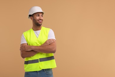 Photo of Engineer in hard hat on beige background, space for text