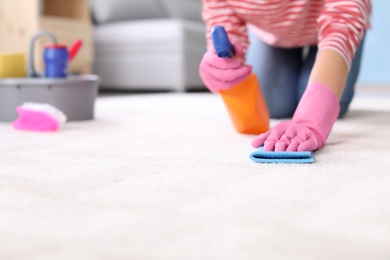 Photo of Woman cleaning carpet at home