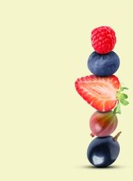 Image of Stack of different fresh tasty berries on honeydew color background, space for text