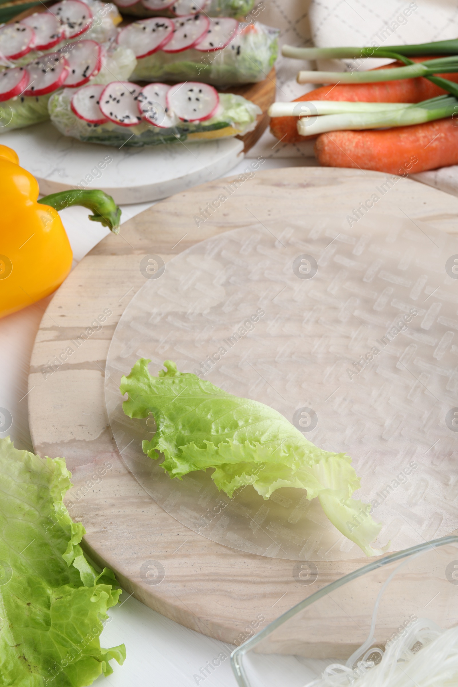 Photo of Rice paper and other ingredients for spring rolls on table