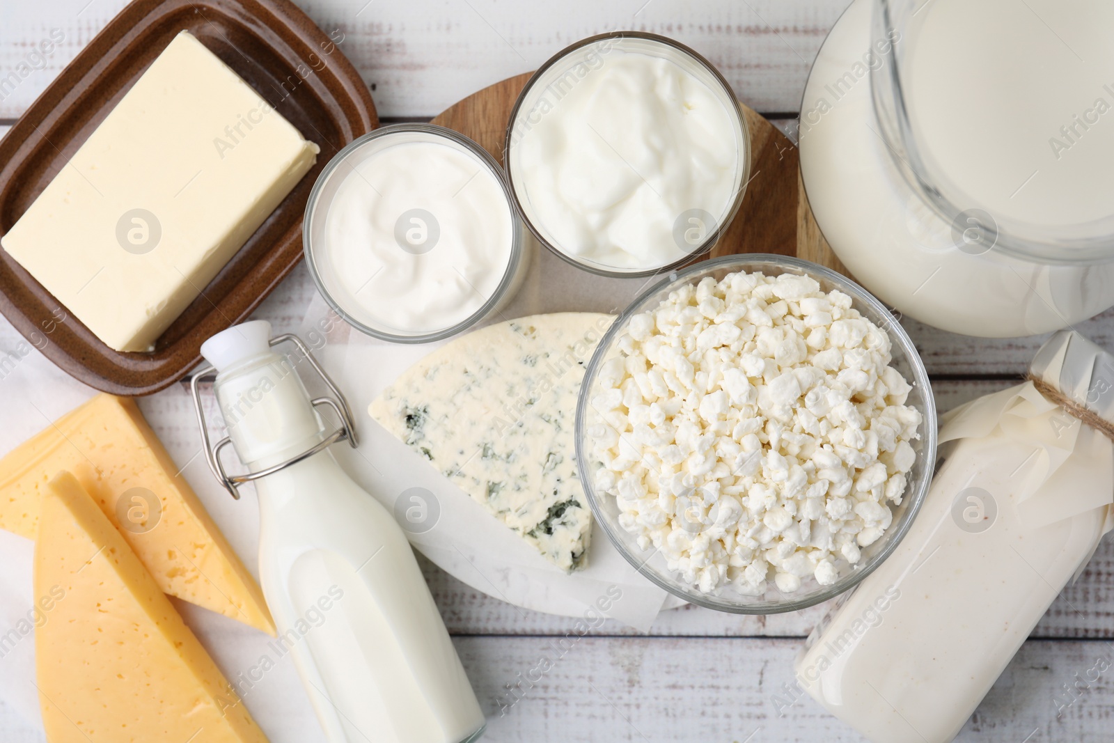 Photo of Different fresh dairy products on white wooden table, flat lay