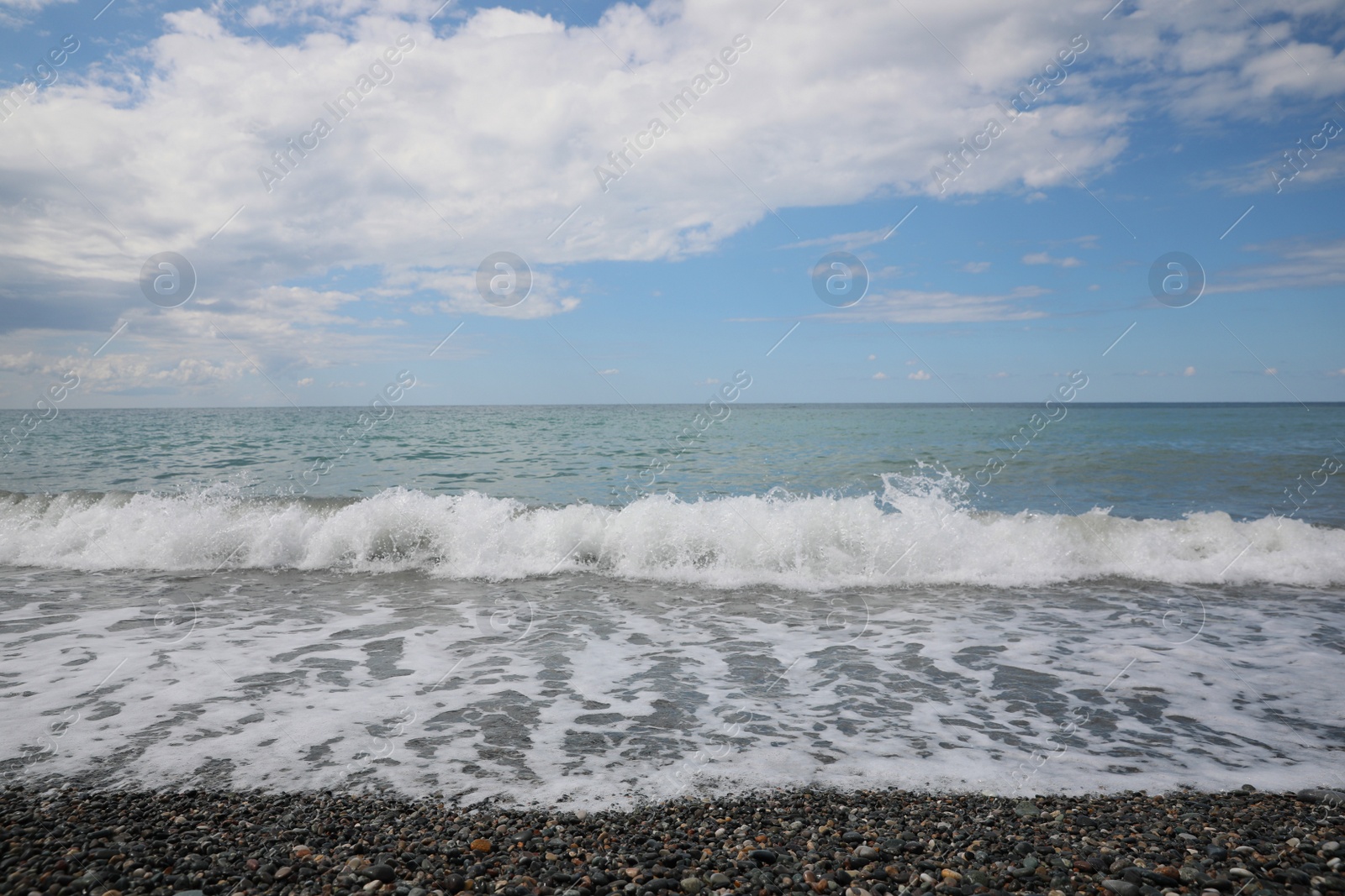 Photo of Picturesque view of beautiful sea shore under sky with fluffy clouds