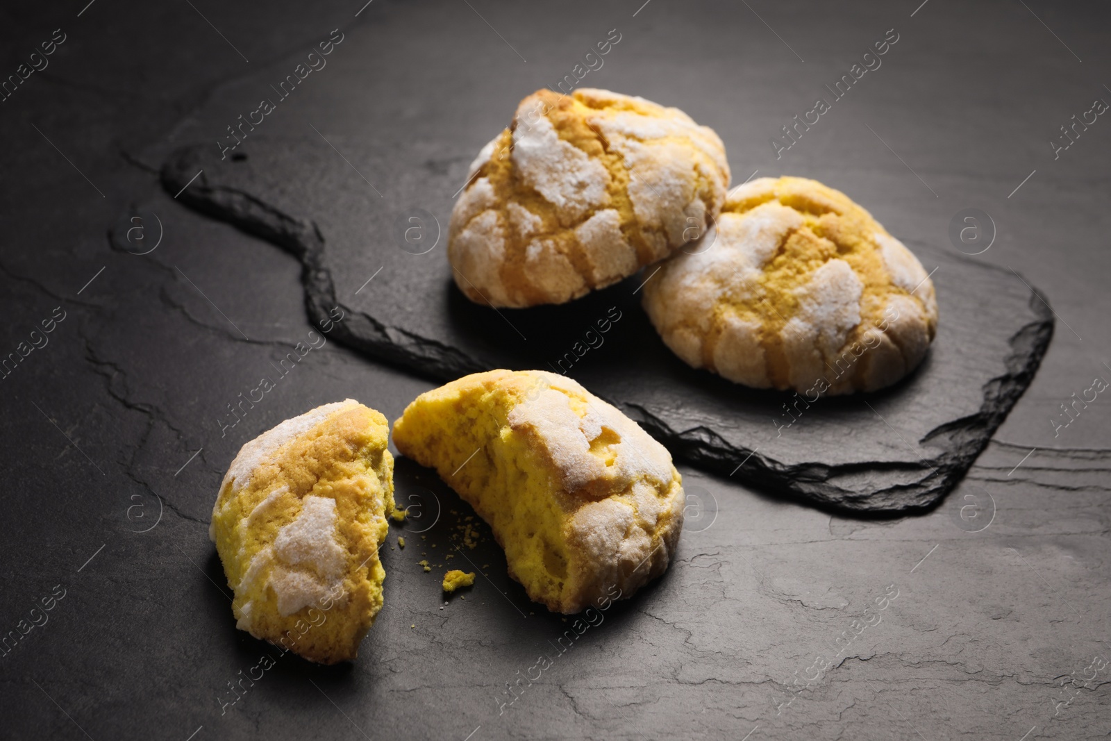 Photo of Fresh delicious lemon cookies on black table