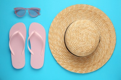 Flat lay composition with straw hat on turquoise background