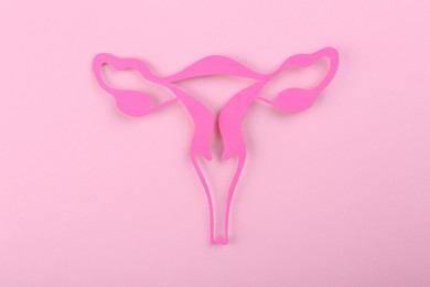 Photo of Reproductive medicine. Paper uterus on pink background, top view