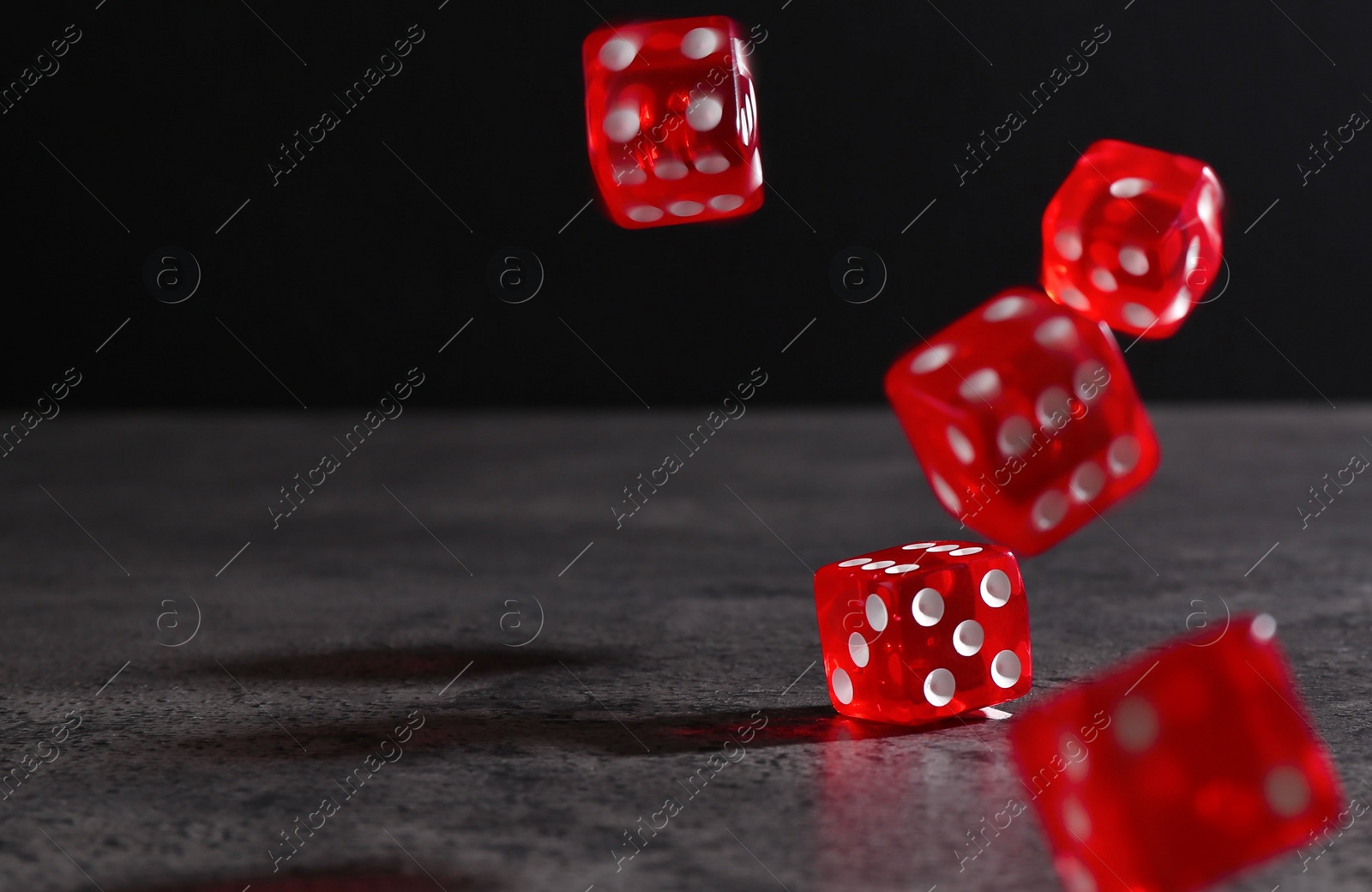 Photo of Many red game dices falling on grey textured table