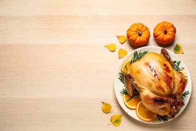 Traditional cooked turkey and autumn decor on wooden table, flat lay with space for text. Thanksgiving day celebration